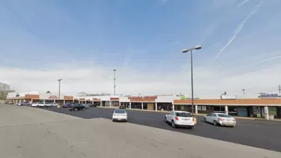 Google Maps view of one-story shopping center with large parking lot.