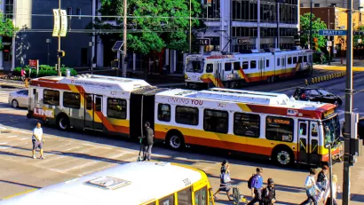 Buses and pedestrians on busy Baltimore street.
