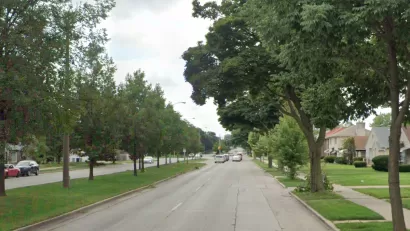 Street view of Sherman Blvd in Milwaukee, Wisconsin with landscaped median in middle of four-lane road.