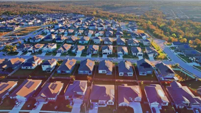 Aerial view of single-family homes with rooftop solar panels in planned development near Austin, Texas.