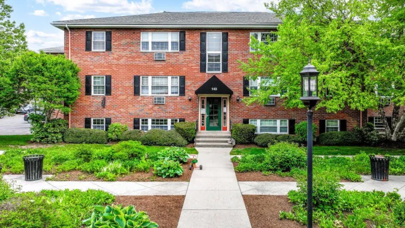 Red brick three-story garden apartment building in Newton, Massachusetts.