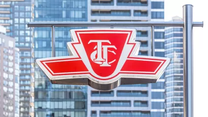 The TTC logo is visible on a sign with the high-rises of Toronto in the background.