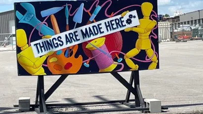 Mural showing tools and craft supplies with banner reading 'Things are made here' in front of makerspace in Columbia, Missouri.