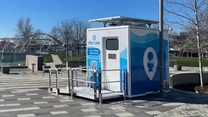 Blue and white Throne portable bathroom in an outdoor location.
