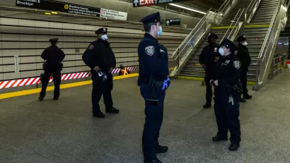 A group of police officers wearing masks during the Covid-19 pandemic gather on a subway platform in New York City.