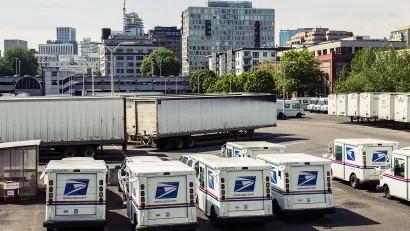 Mail delivery trucks in the parking lot at the United States Postal Service (USPS) main post office and distribution facility at 715 NW Hoyt Street in Portland, Oregon.