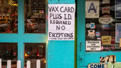 A sign outside a shop reads "VAX Card plus I.D. required for entry, no exceptions."