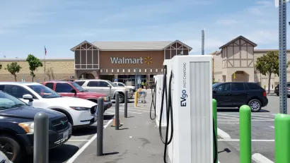 Electirc vehicle charing stations are visible in the parking lot of a Walmart store.