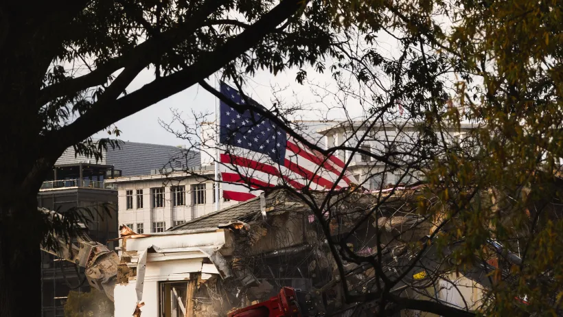 East Wing of White House with demolition equipment and visible American flag.