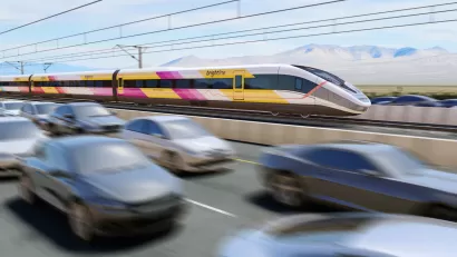 Rendering of white, yellow, and purple Brightline West high-speed rail train speeding along highway median with blurred cars in foreground.