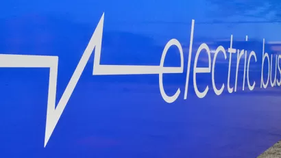 Close-up of white "electric bus" logo on side of blue Chicago public transit bus