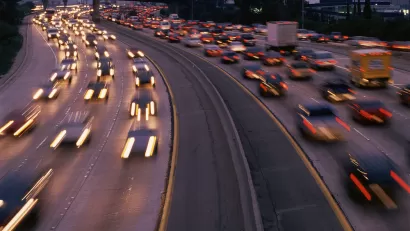 View of blurry speeding cars on freeway at sunset