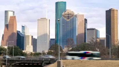 View of Houston freeway with bus, cars, and downtown skyline in background