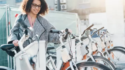 Woman accessing bike at bike share station