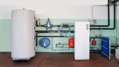 Geothermal heat pump installed on wall next to water boiler