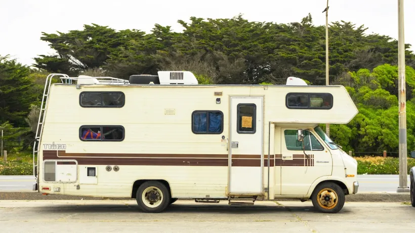 Small recreational vehicle parked on city street.