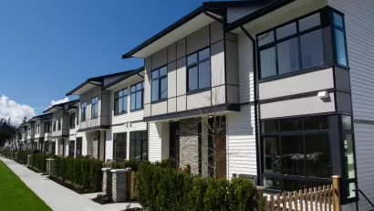 Row of white two-story townhomes with black trim