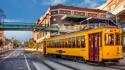 Yellow Tampa streetcar passingon street in Ybor City