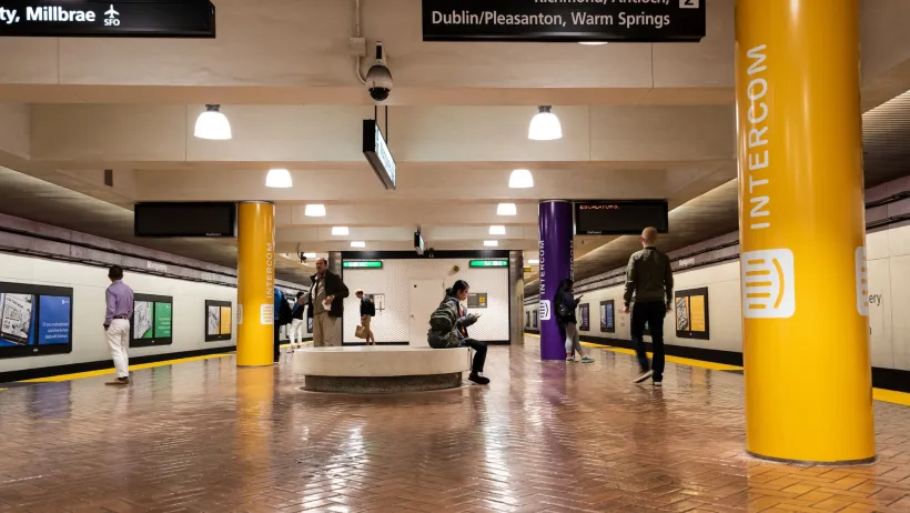 Underground transit station in San Francisco, California with few passengers waiting for trains.