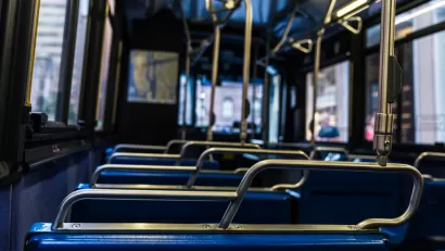 Close-up view of empty bus from behind seat. Seats have blue upholstery