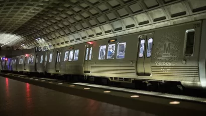 Silver DC Metro train in underground station with high arched ceiling