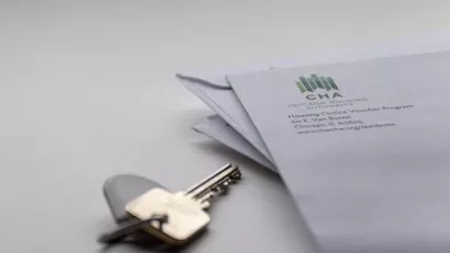 Close-up of house key on table and corner of envelope from Chicago Housing Authority