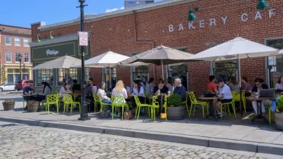 Outdoor dining with bright green chairs on a sidewalk in Baltimore, Maryland