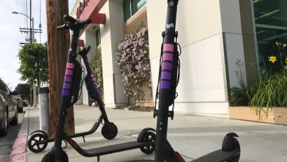Three Lyft electric scooters parked on a sidewalk in West Los Angeles
