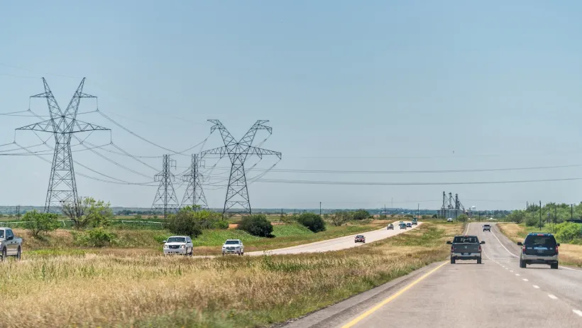 Highway road 84 near Snyder, Texas countryside with cars in traffic and power lines cables.