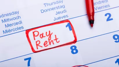 Close-up of calendar on day 1 of month with "Pay Rent" written in red marker