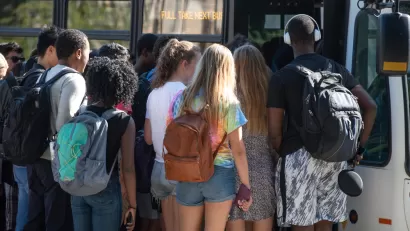 Group of diverse college students boarding crowded bus