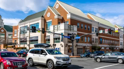 View of intersection in Fairfax, Virginia with three-story building and cars in intersection