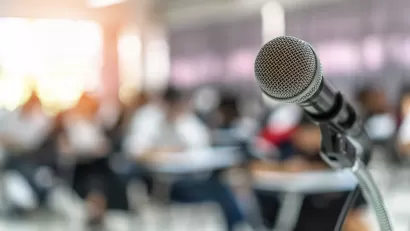 Close-up of microphone on stand with blurred seating in background