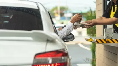 Driver reaching for chagne at drive-through window