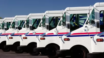 A row of USPS delivery trucks