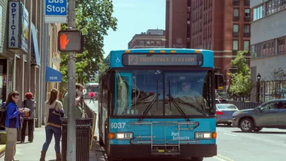 Bus stop in Pittsburgh, Pennsylvania with blue bus and passengers boarding