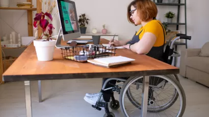 Woman in wheelchair working at a home office desk