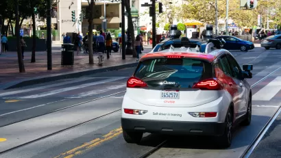 Red and white Cruise autonomous Chevy Bolt on San Francisco street
