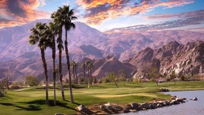 Golf course with palm trees and mountains in background in Palm Springs, California