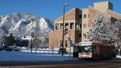 Bus stop in Boulder, Colorado with snowy tree and snowy mountains in background