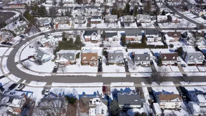 Aerial view of snowy single-family homes in suburban Long Island, New York