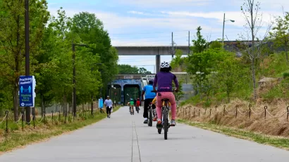 People on bikes ride along paved Atlanta BeltLine bike trail