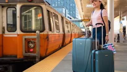 Orange Line platform with woman waiting with suitcases, Boston, Massachusetts