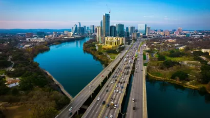 Aerial view of Interstate 35 bridge over river into downtown Austin, Texas with skyline in background