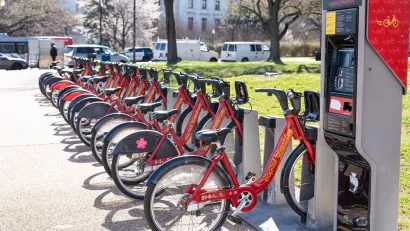 Station with rown of red Capital Bikeshare parked bikes on Washington, D.C. sidewalk