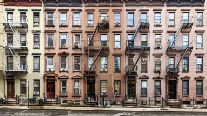 Multicolored four-story brick New York City apartment buildings with fire escapes