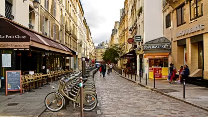 Street in Paris Latin Quarter with row of bicycles, cobblestone street, and pedestrians