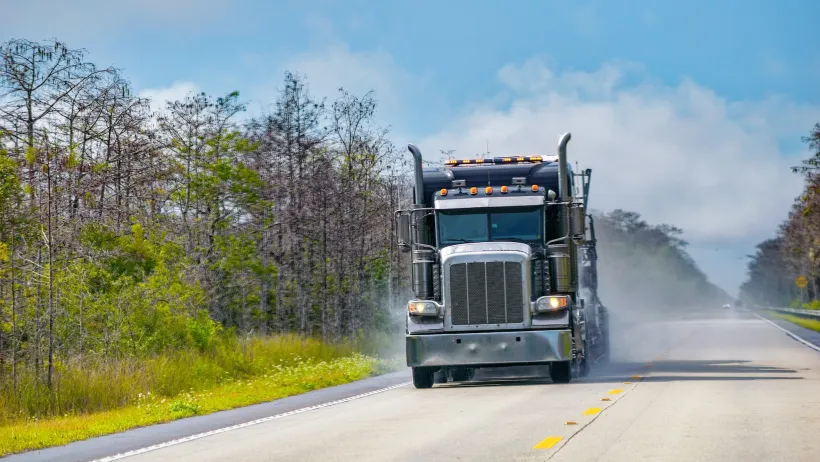 Big rig truck driving alone down two-lane Florida highway.