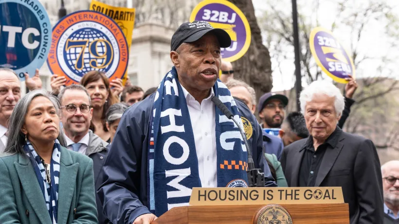 New York City Mayor Eric Adams speaking at an outdoor lectern.