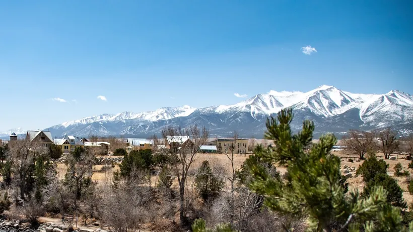 View of small mountain town of Buena Vista, Colorado with snow-capped mountains in background.